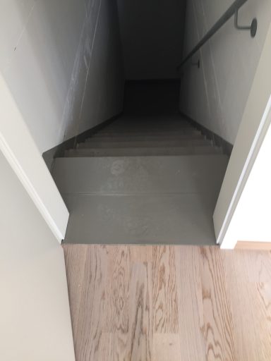 Ein Blick auf eine Treppe, die in einen dunklen, schmalen Raum führt.